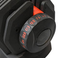 Close-up of a black weight plate with red measurement markings on a white background