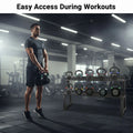 Man holding a kettlebell with a rack of kettlebells in a gym setting