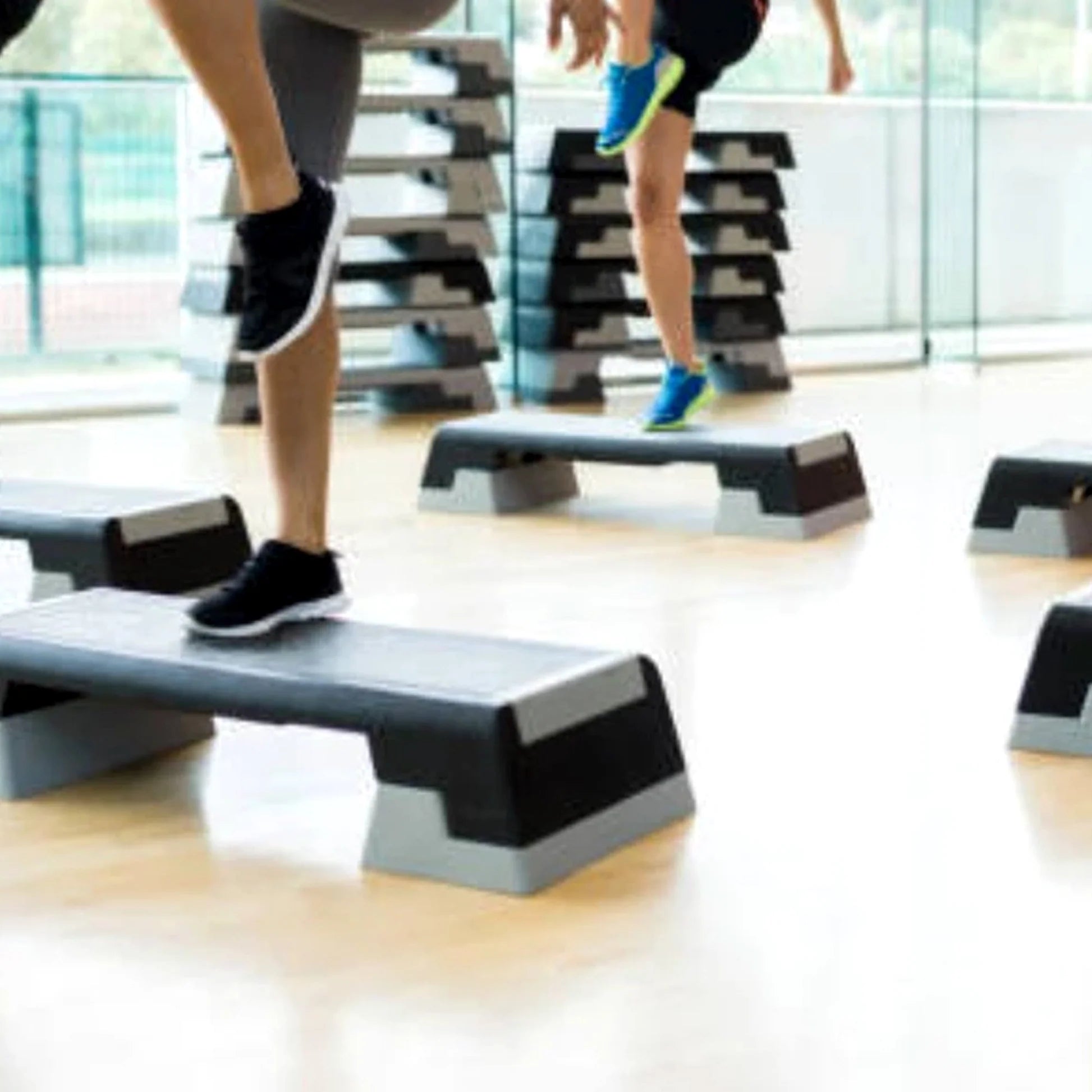 People exercising on step platforms in a gym setting