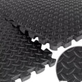 Stack of black interlocking foam mats with textured surface