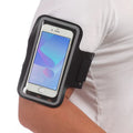 Person wearing a black arm band with a smartphone on a white background